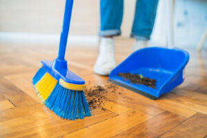 Portrait,Of,Young,Latin,Man,Sweeping,Wooden,Floor,With,Broom